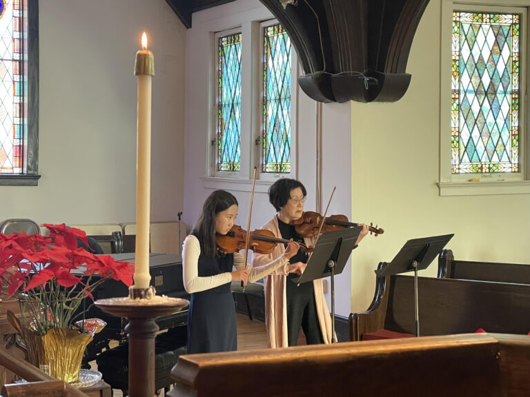 Grace and Yuko playing violin at worship.